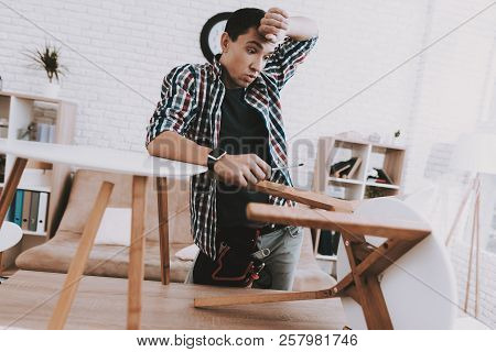 Young Man Assembling Coffee Table And Stools. Furniture Fittings. Engineer With Tool. Young Man At H