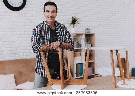 Young Man Assembling Coffee Table And Stools. Furniture Fittings. Engineer With Tool. Young Man At H