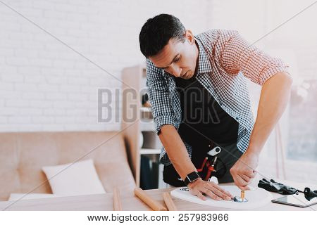 Young Man Assembling Coffee Table And Stools. Furniture Fittings. Engineer With Tool. Young Man At H