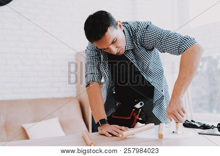 Young Man Assembling Coffee Table And Stools. Furniture Fittings. Engineer With Tool. Young Man At H