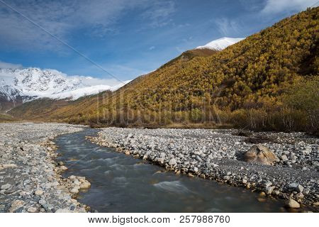 Autumn landscape with a mountain river Enguri. View to the top of Shkhara. Main Caucasian ridge. Zemo Svaneti, Georgia