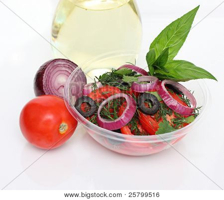 Salade fraîche dans un bol en plastique isolé sur fond blanc