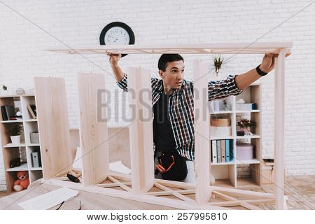 Young Man Assembling Wooden Bookshelf At Home. Wooden Bookcase. Selfmade Furniture. Man And Hobby. W