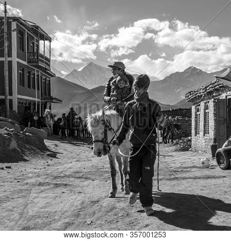 Man Leading Horse With Two Riders