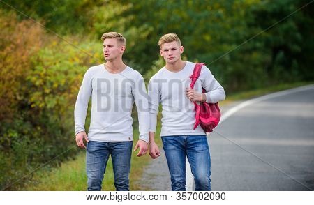 Means Of Travel. Twins Walking Along Road. Two Brothers Go Adventure. Friendship. Men Hitch Hiking. 