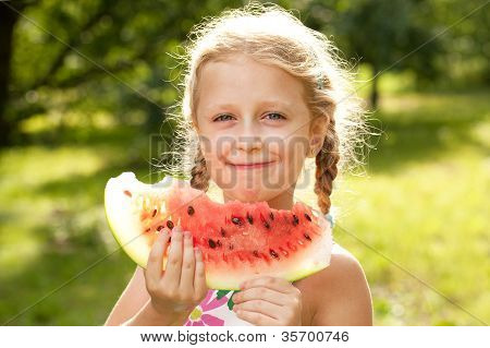 Beautiful Blonde Girl With Pigtails Eating A Watermelon