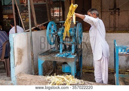 Eklingji, India - March 15, 2020: Man Prepares Sugarcane To Make Juice Along The Roadside To Sell