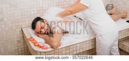 Luxury Relaxation Oriental Man In A Turkish Bath. Hammam Worker Washes Mens Skin In Hammam