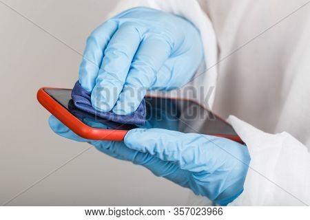 Hands In Protective Gloves And Siut Cleaning Phone From Dust And Infection On White Background