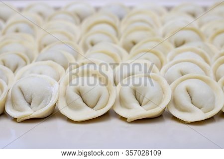 Uncooked Russian Pelmeni On Cutting Board. Vertical