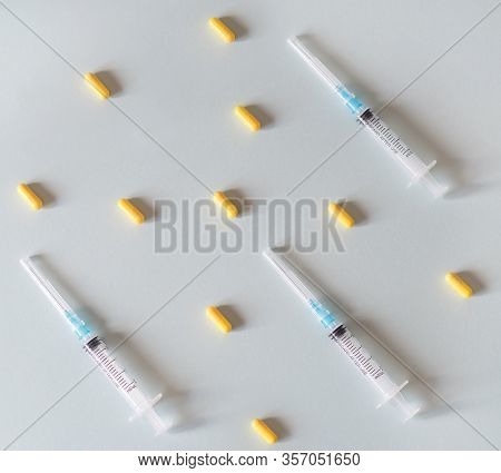 Pills And A Syringe On A Light Gray Background.