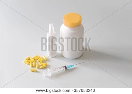 A Jar Of Pills And Yellow Capsules With A Syringe Lie On A Light Background For An Article On Medici