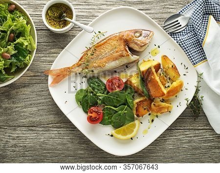 Delicious Grilled Fish Meat With Spinach And Potatoes On Vintage Background. Healthy Diet Meal