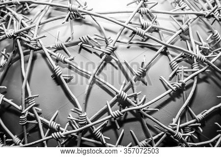 Iron Barbed Wire Covered With White Paint, Tightly Wound And Crossed Creating A Pattern On A White B