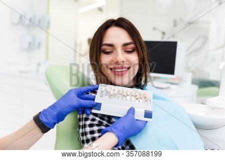 Dentist And His Patient Choose A Tone Of Veneers. Dentistry Doctor Shows A Palette With Shades For T
