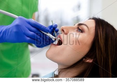 Woman Treats Teeth At The Dental Clinic.  Dentist Doctor Uses Drill To Drilling Patient Teeth