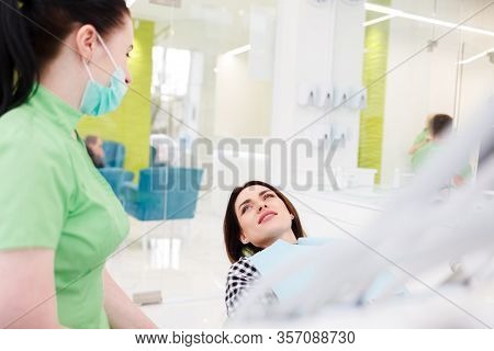 Dental Clinic Patient Is Lying In A Chair And Talking To A Doctor