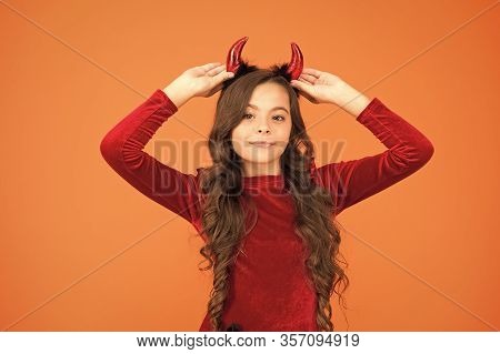 Fancy Imp. Little Girl Red Horns Celebrate Halloween. Carnival Concept. Small Child With Imp Style A