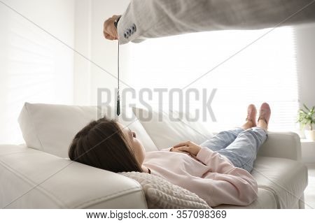 Psychotherapist Using Pendulum During Hypnotherapy   Session In Office