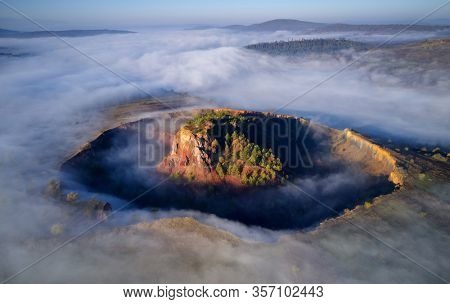 aerial view of volcanic crater in Racos village, Brasov county, Romania - foggy autumn morning