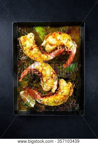 Traditional barbecue spiny lobster tail sliced and offered with saffron lemon sauce as top view on a metal tray with copy space 