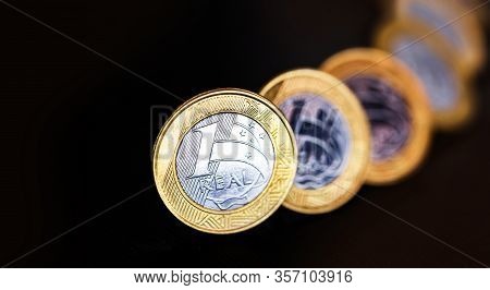 Images Of One Real Coins, Money From Brazil On Isolated Black Background. Falling Real Of The Brazil
