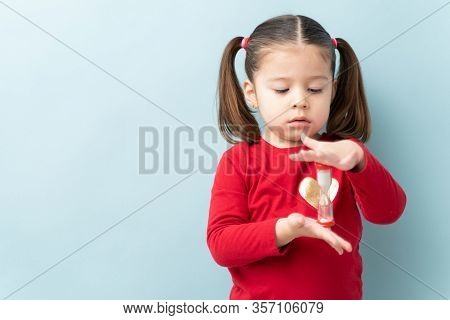 Serious Looking Little Girl Looking At A Sand Timer While Practicing Self-control During Timeout In 