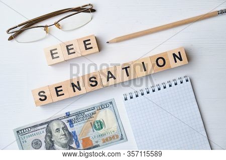 Modern Business Buzzword - Eee Sensation. Top View On The Board, Glasses, Pencil, Dollar And Notepad