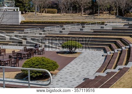 Daejeon, South Korea; March 16, 2020: Unidentified Man Wearing Gray Coat And Using Cellphone, Sittin