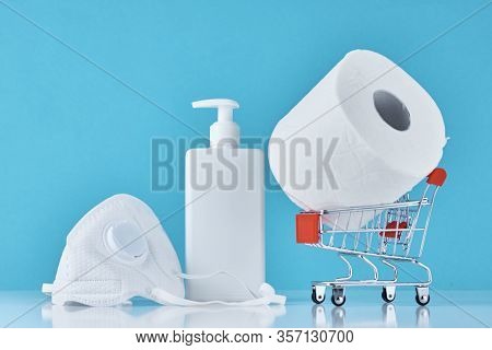Toilet Paper Roll, Sanitizer Antiseptic Gel And Protective Mask On Blue Background. People Are Stock