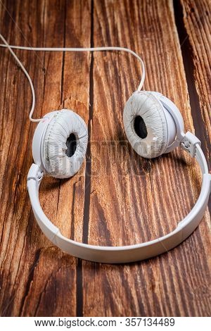 Need A Replacement Embouchures On Old White Earbud. Repair Accessories.wooden Background