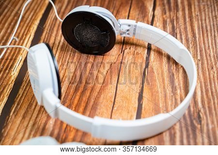 Need A Replacement Embouchures On Old White Earbud. Repair Accessories.wooden Background