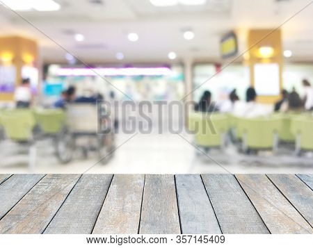 Wooden Table Top Over Blur Background Of People Waiting To Receive The Medicine At The Counter In Ho