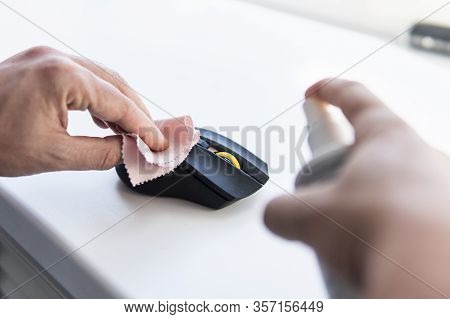 A Man Wipes A Dirty Mouse With A Rag . Cleaning The Computer Mouse. Removing Microbes With An Alcoho