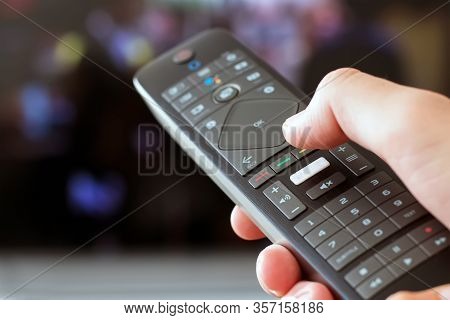Hand Holding A Remote Control Close-up Tunring On Tv