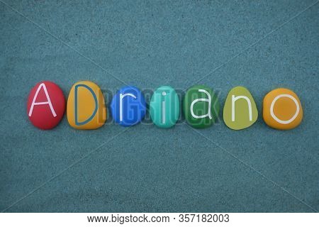 Adriano, Latin Male Name Composed With Multi Colored Stone Letters Over Green Sand