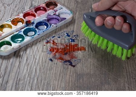 The Woman Brushing The Stain From The Paint. Clean Up, Wash. A Mess. A Hand Wipes The Stain From The