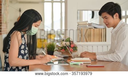 Girls Wearing Mask And Men Not Wearing Mask Working In A Cafe. He And She Risk Becoming Infected Wit