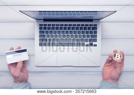 Bitcoin Vs Bank Card Online Shopping And Trading Concept. Man Decides How To Pay. Toned Picture.