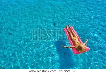 Woman relaxing on inflatable mat float at the beach