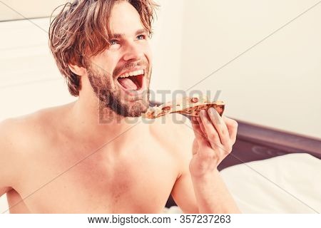 Cropped Image Of Shirtless Sexy Man With Pizza On Bed. Man Bearded Handsome Guy Eating Cheesy Food F