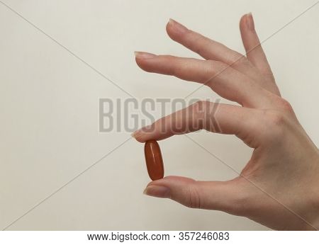 Female Hand Holds A Tablet, Capsule In Hands. On White Background. Pharmaceuticals. Allopathic Medic