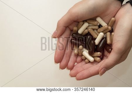 Female Hand Holds A Tablet, Capsule In Hands. On White Background. Pharmaceuticals. Allopathic Medic