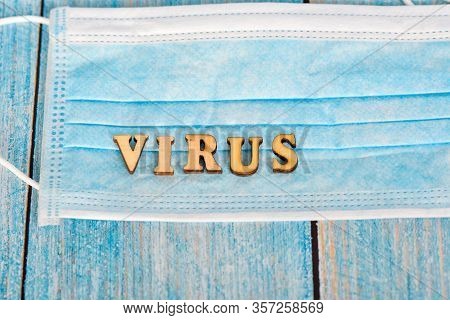 The Inscription Virus In Wooden Letters On A Protective Mask On A Blue Background.