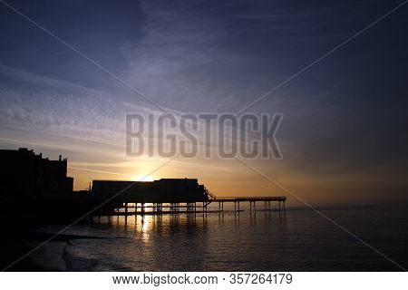 The Victorian Pier In Aberystwyth Silhouetted At Sunset