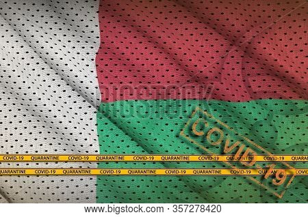 Madagascar Flag And Orange Covid-19 Stamp With Border Tape. Coronavirus Or 2019-ncov Virus Concept