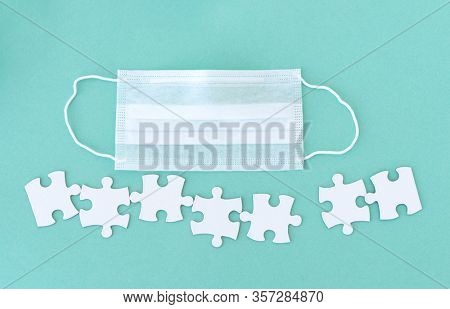 Medical mask and jigsaw puzzle pieces with copy space