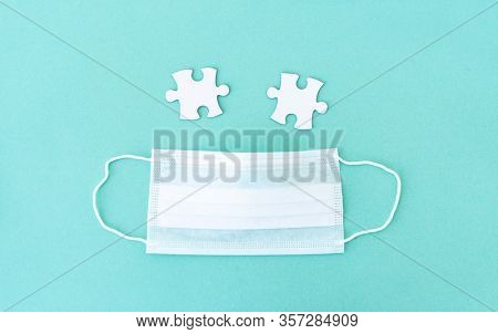Two empty jigsaw puzzle pieces near medical mask