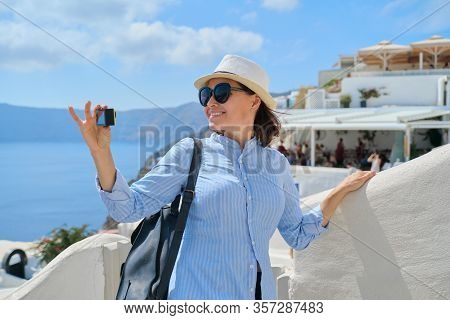 Woman Travel Vloger Traveling In Greek Village Of Oia On Santorini Island, Filming Aktion Camera Vid