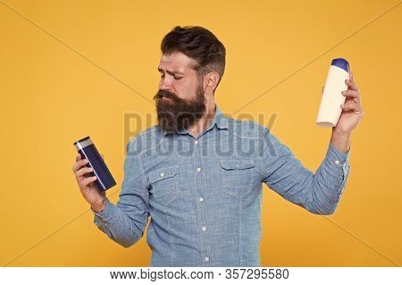 Bath Cosmetics Review. Man Bearded Hipster Hold Plastic Bottles. Hair Care. Skin Lotion. Picking Pro